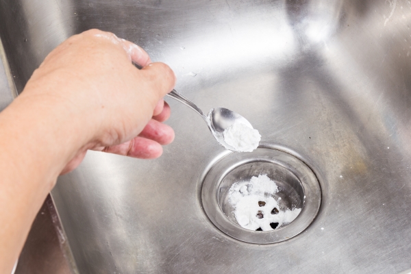 将小苏打放下厨房水槽排水管的人有助于清除堵塞。